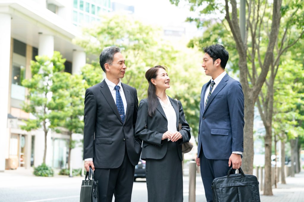 通りで会話するビジネスパーソンと顧客