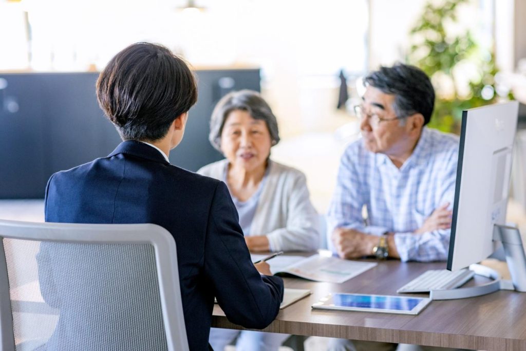 スーツの男性と打ち合わせをするシニア夫婦