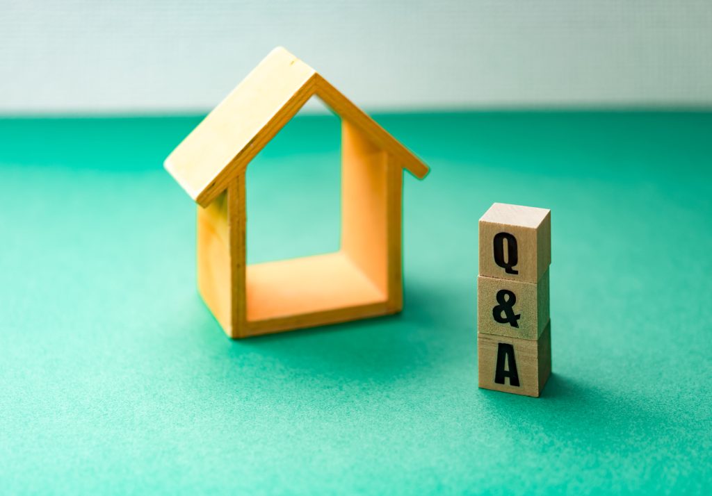 木製の家の模型と「Q&A」と書かれた積み木ブロック