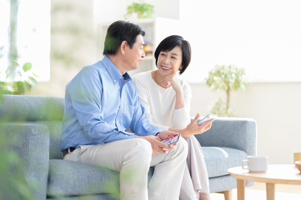 ソファに並んで座り、笑顔を浮かべるミドル夫婦