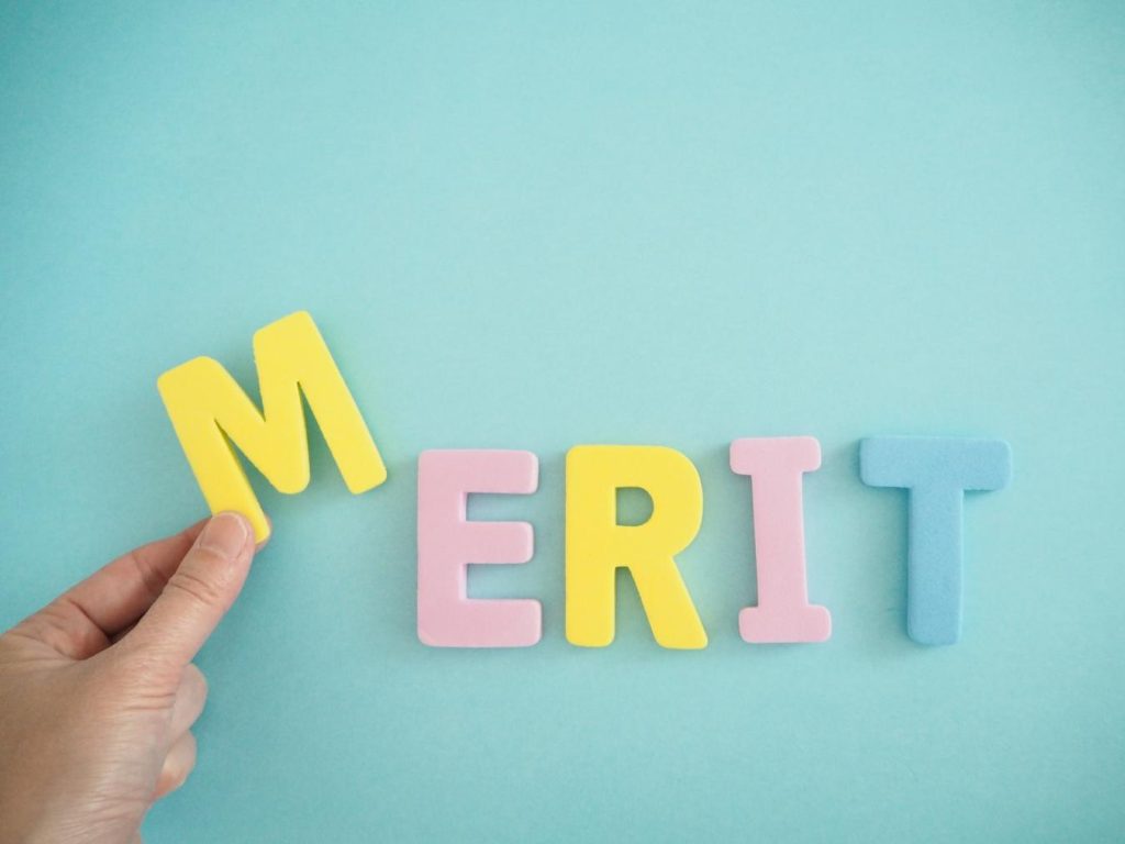 「MERIT」と並ぶ文字と「M」を持つ手
