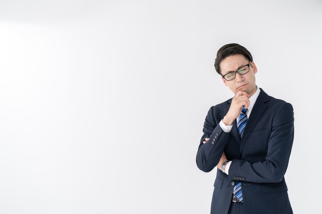 考え込むスーツ姿の男性