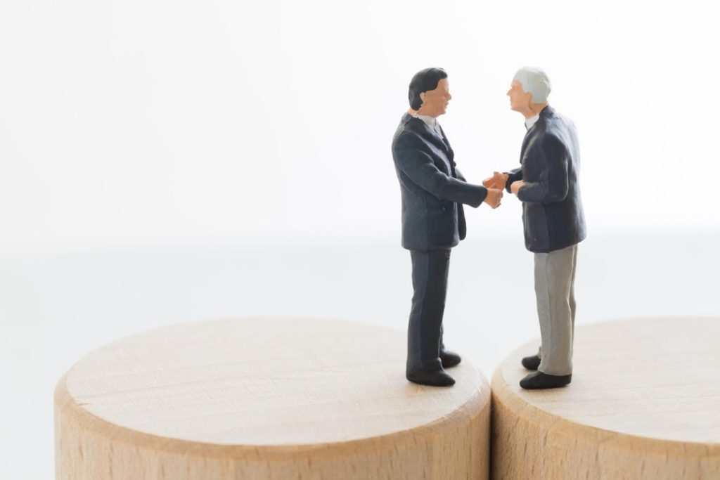 2人の人物ミニチュアが向かい合い握手している様子