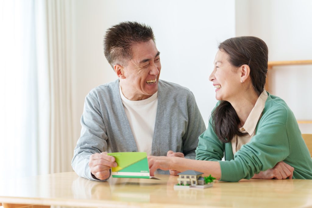 通帳を見て微笑むシニア夫婦