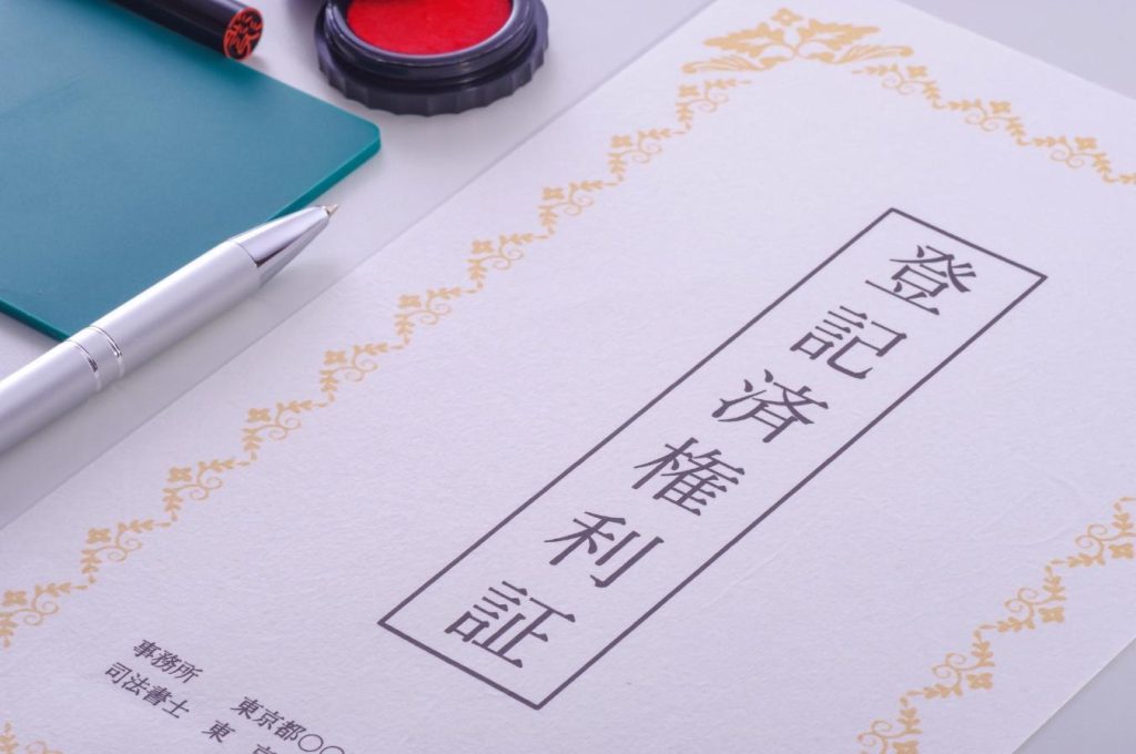 机に置かれた登記済権利証と朱肉、印鑑、ペン