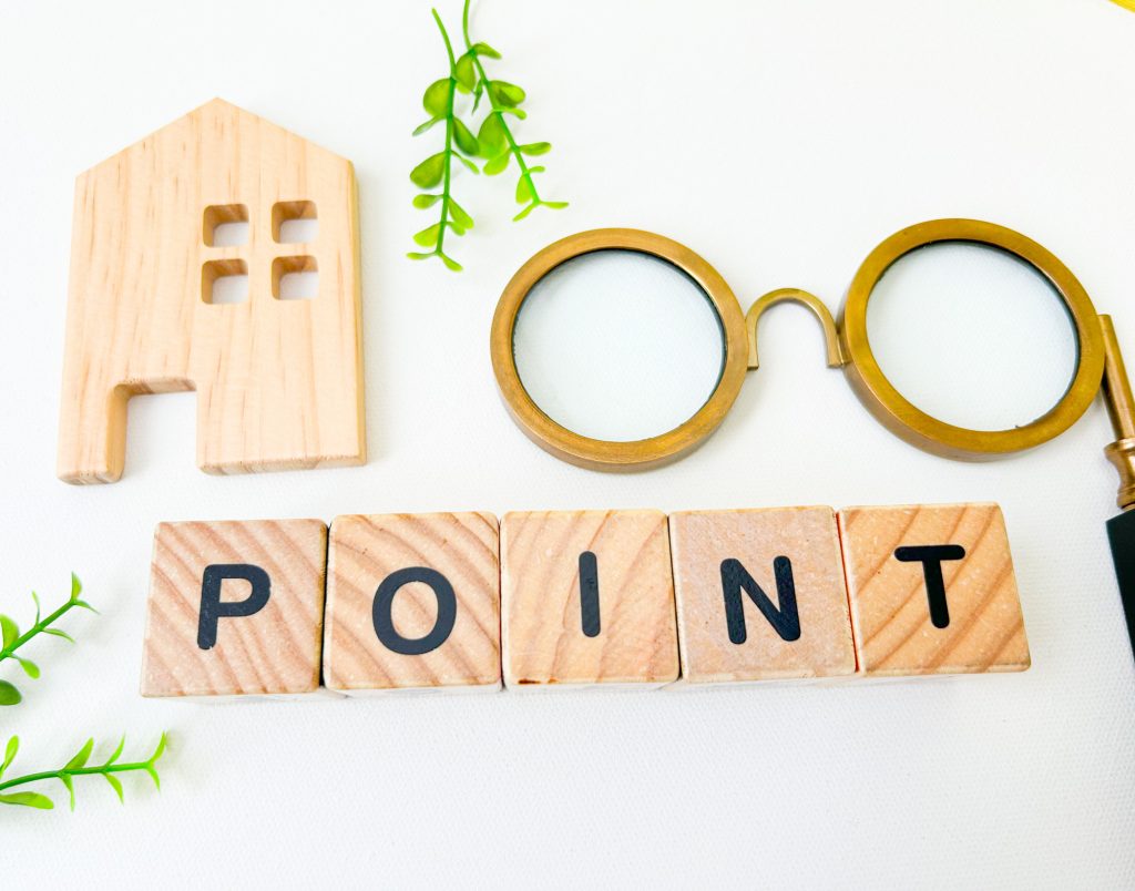 木製のブロックで「POINT」と並べられ、その上に家のモチーフとルーペが配置されたイメージ