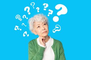 顎に手を当てて悩むシニア女性とたくさんのクエスチョンマーク