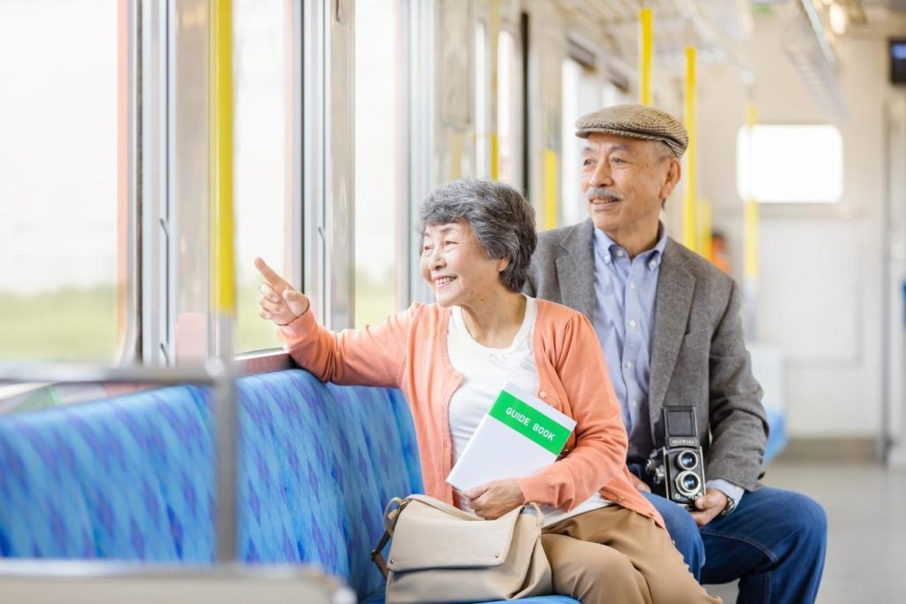 電車で旅行を楽しむシニア夫婦