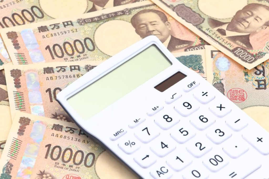 1万円札の上に置かれた電卓
