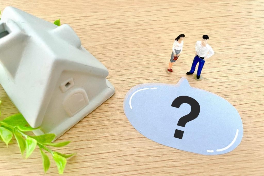 家と男女2人の模型、「?」と書かれた紙