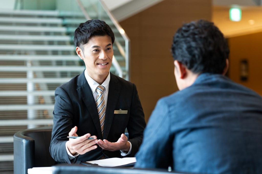 向かい合って話をするスーツ姿の男性
