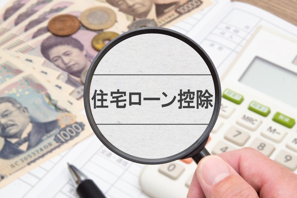 虫眼鏡で覗いた「住宅ローン控除」の文字と現金、電卓

