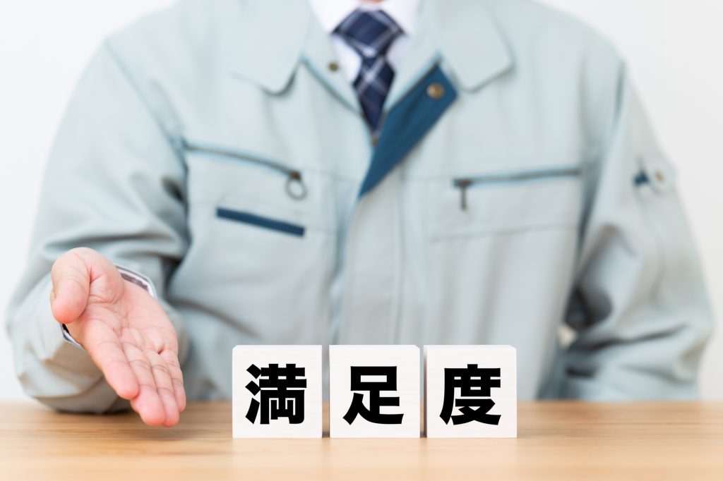満足度のブロックと作業着を着たビジネスマン