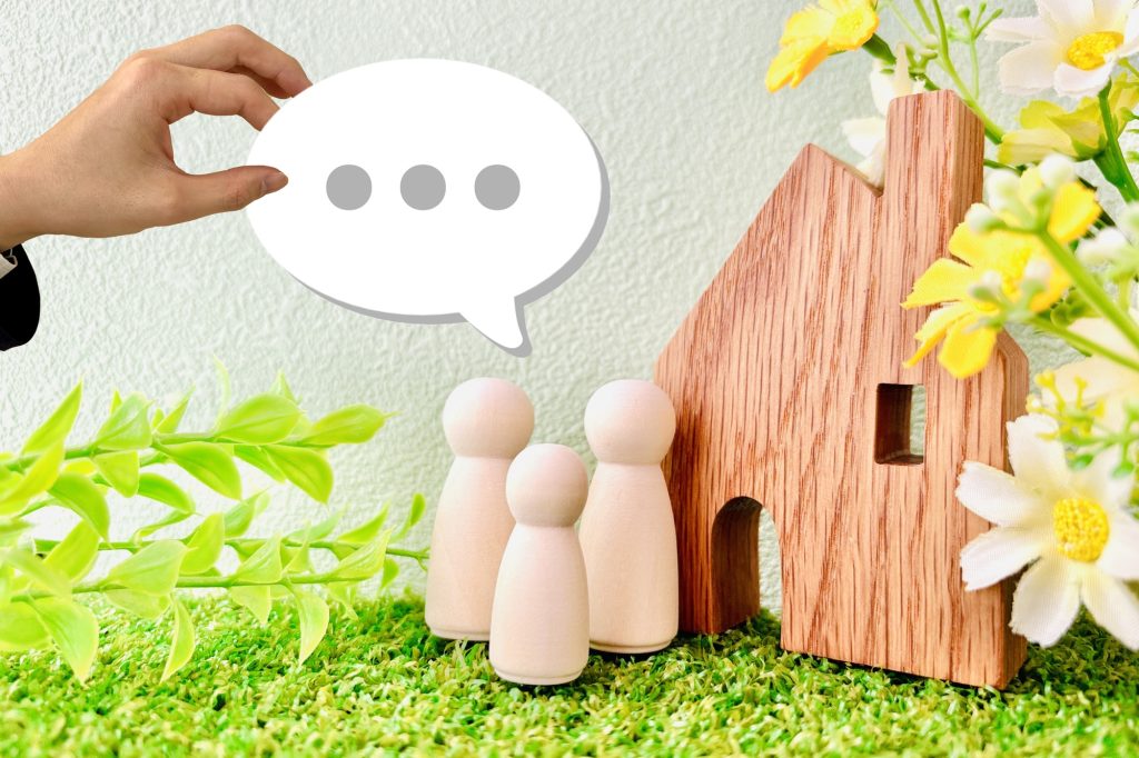 住宅模型と家族のモチーフに吹き出しを添え、住まいに関する口コミや評判をイメージした写真