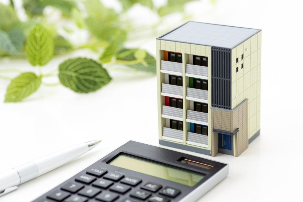マンションの模型と電卓、ペン。