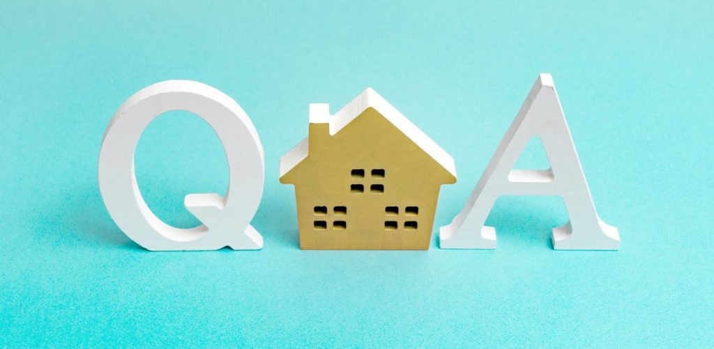 「Q」と「A」の文字の形をした模型と、その間に置かれた家の模型