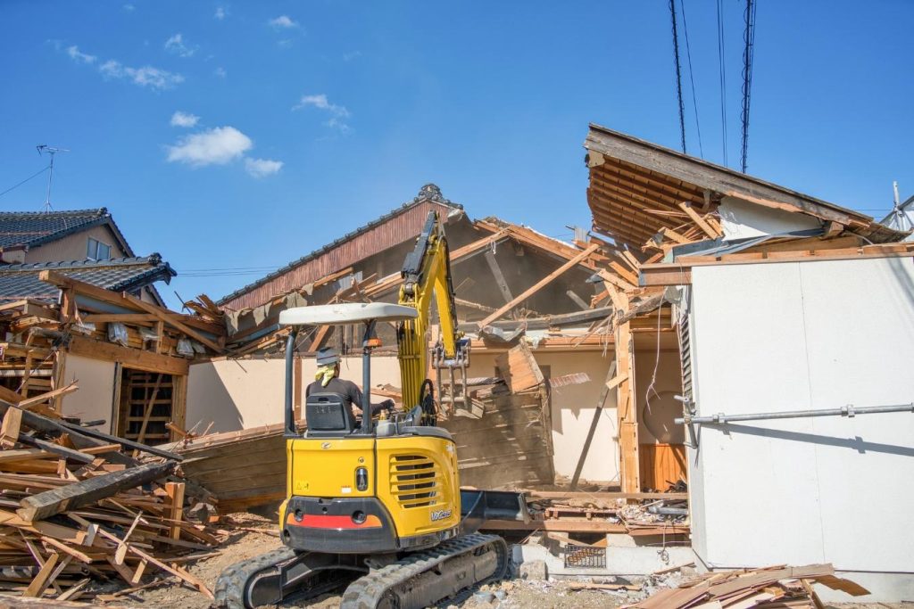 木造住宅を重機で解体する様子