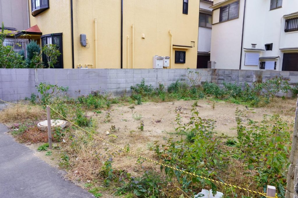 住宅街にある雑草が生えた空き地
