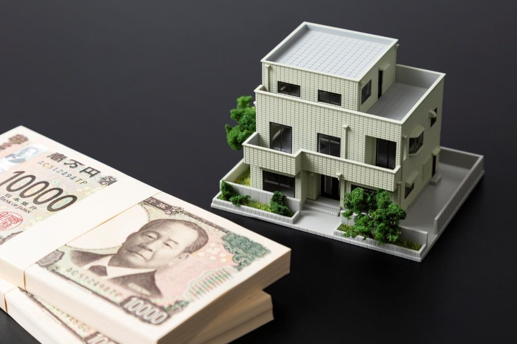 家の模型と一万円札の束