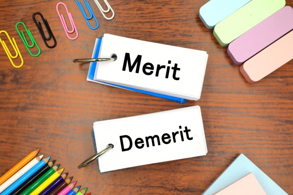 「Merit」「Demerit」と書かれた単語帳とさまざまな文房具