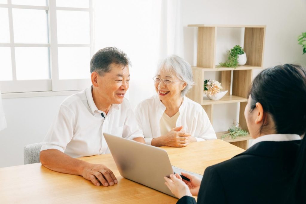 営業担当者と笑顔で打ち合わせをする夫婦。
