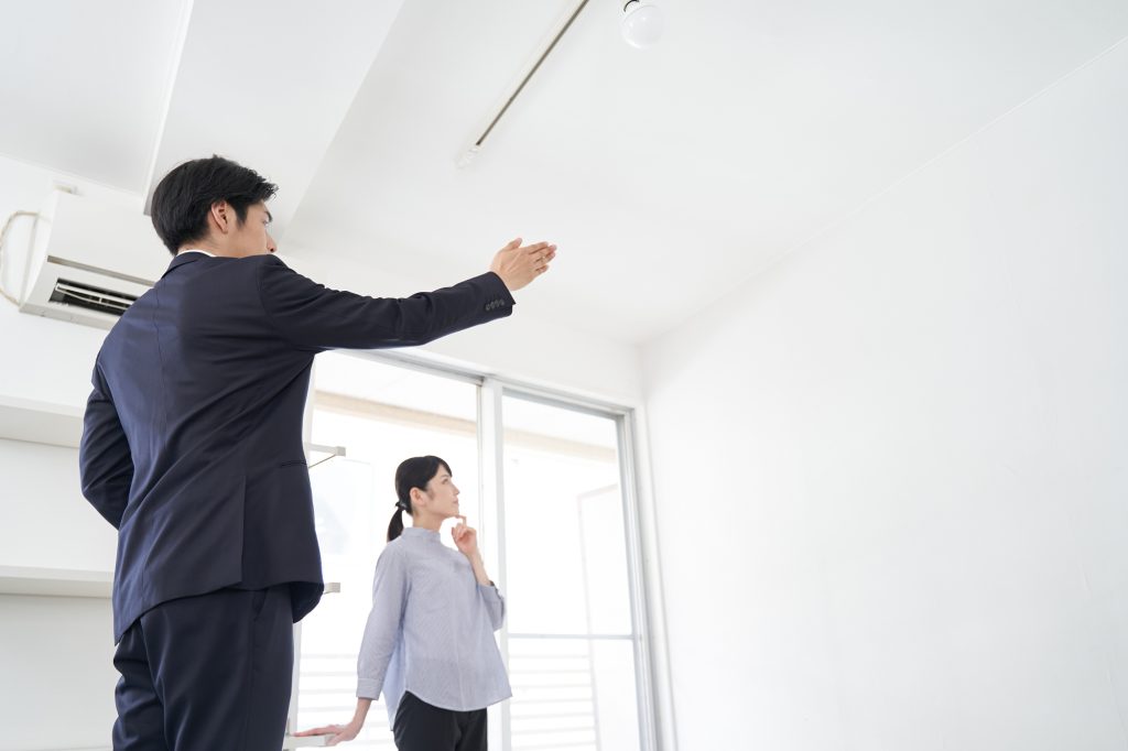 室内を案内する不動産営業の男性と説明を聞く女性