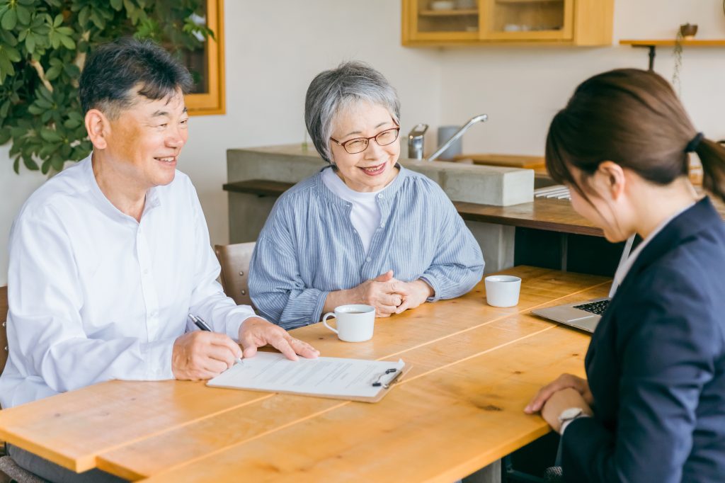 担当者と契約書を確認するシニア夫婦