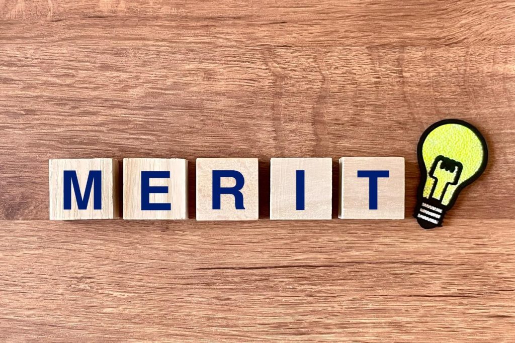 『MERIT』と書かれた木のブロック。