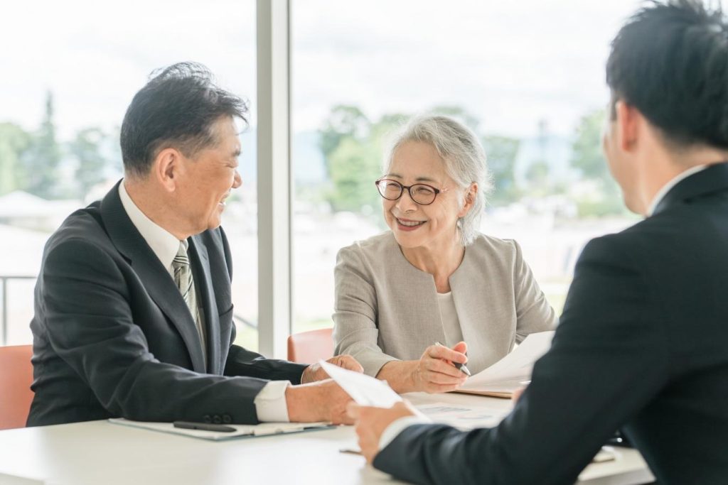 営業担当者との打ち合わせで笑顔を浮かべる夫婦。