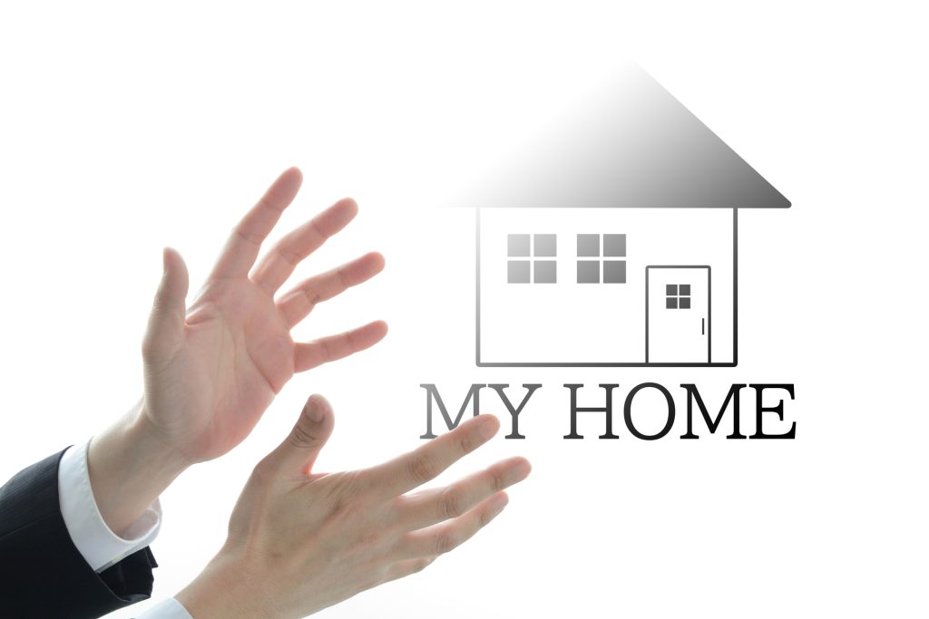 家のイラストと「MY HOME」の文字に向けて伸ばされたスーツ姿の人物の両手