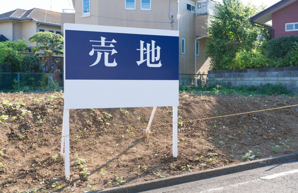 売地の看板と戸建て住宅