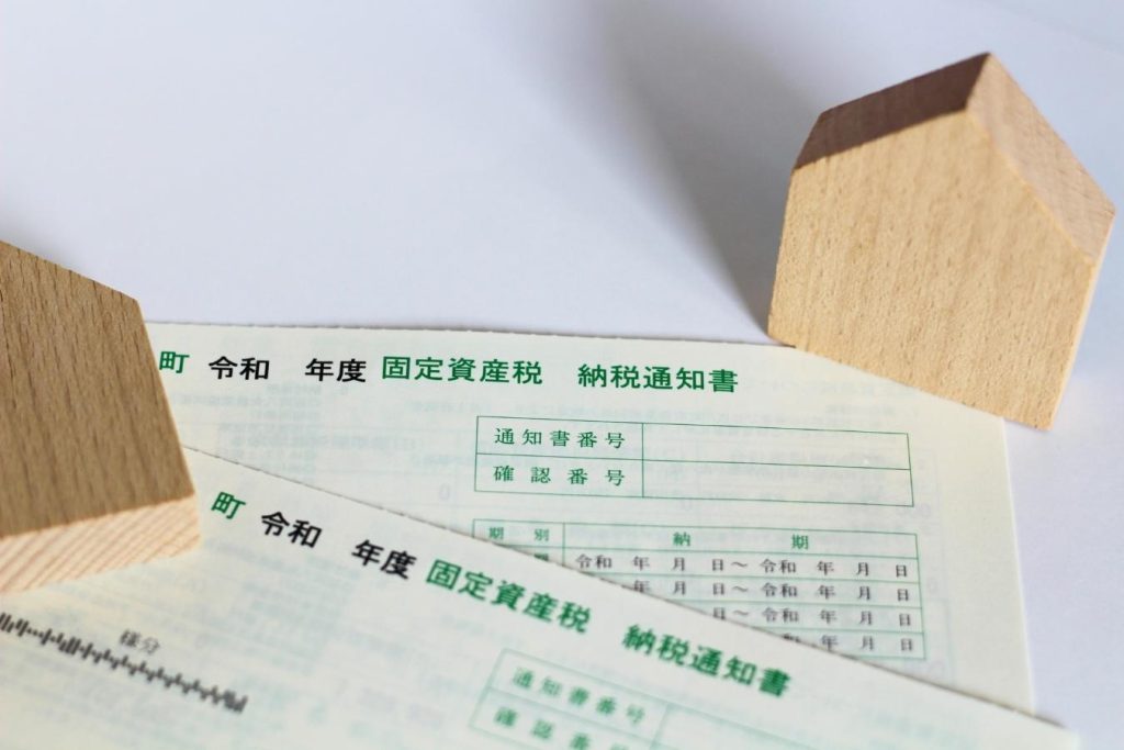固定資産税納税通知書と家の模型。