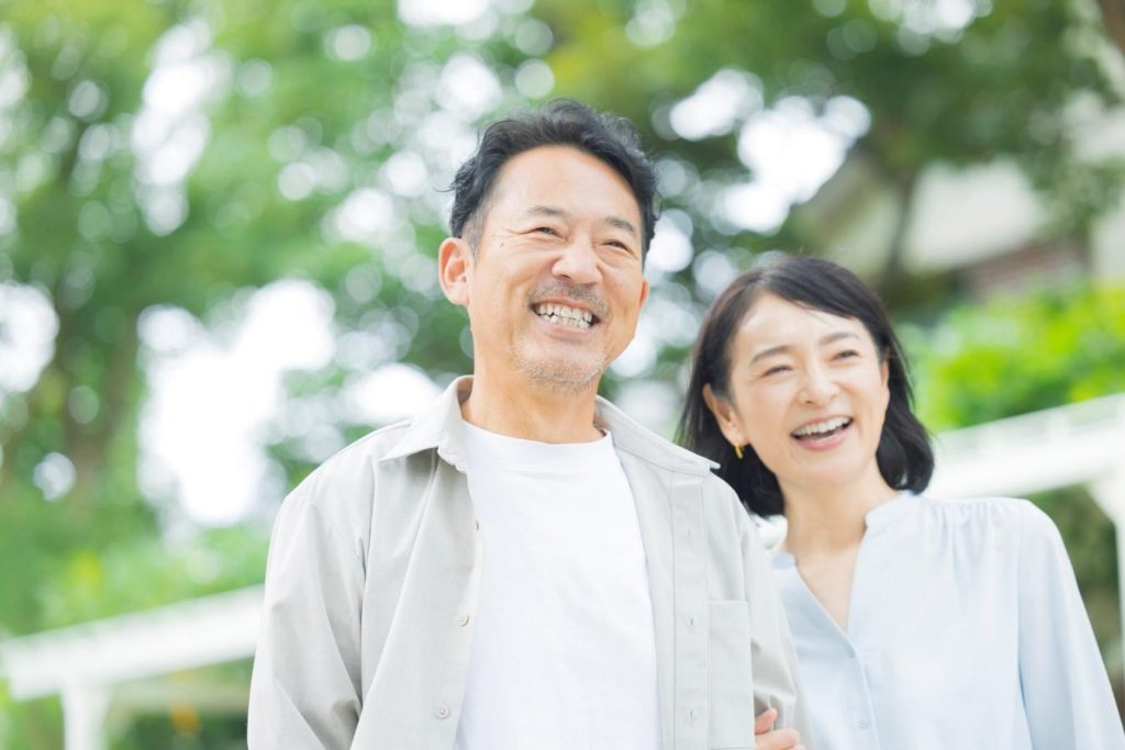 外を歩きながら笑顔で寄り添う夫婦