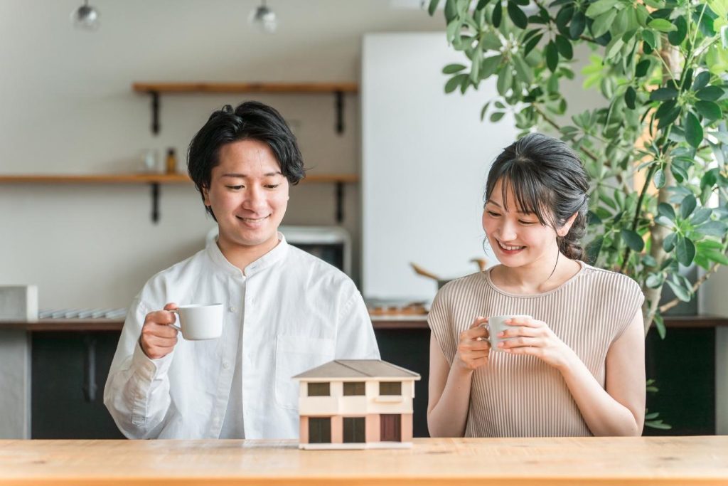 家の模型を見ながら笑顔を浮かべる夫婦