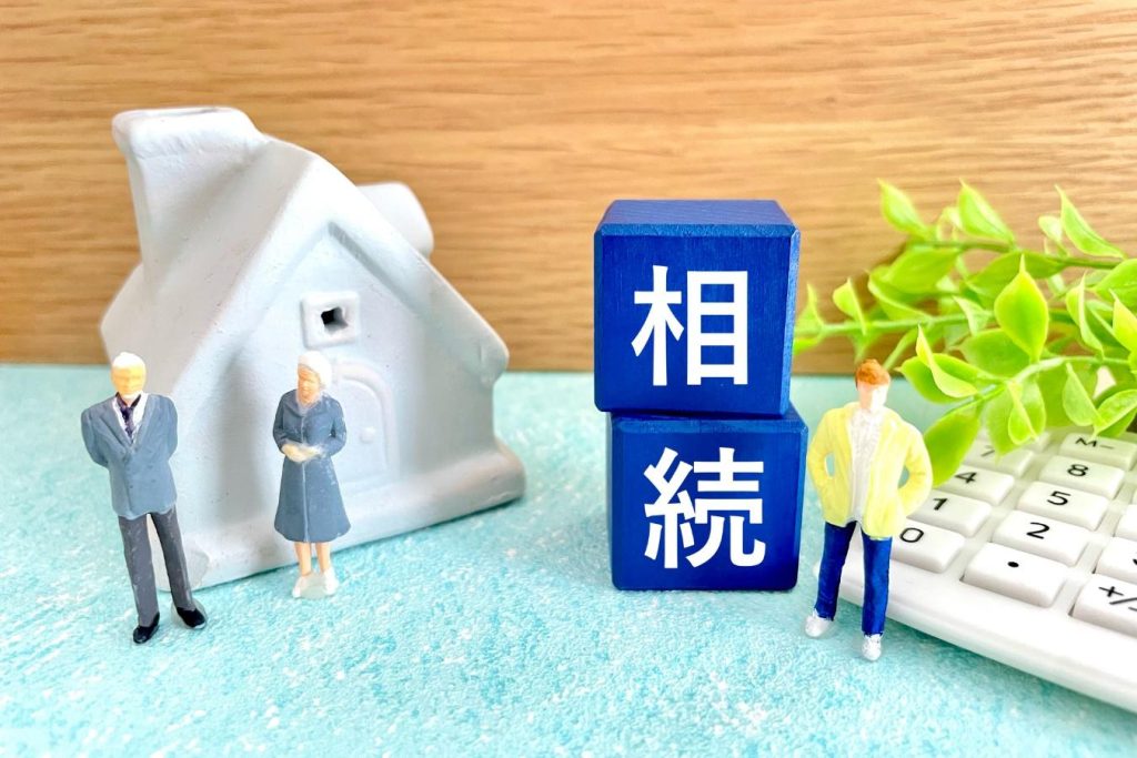 「相続」と書かれたブロックと家や人の模型