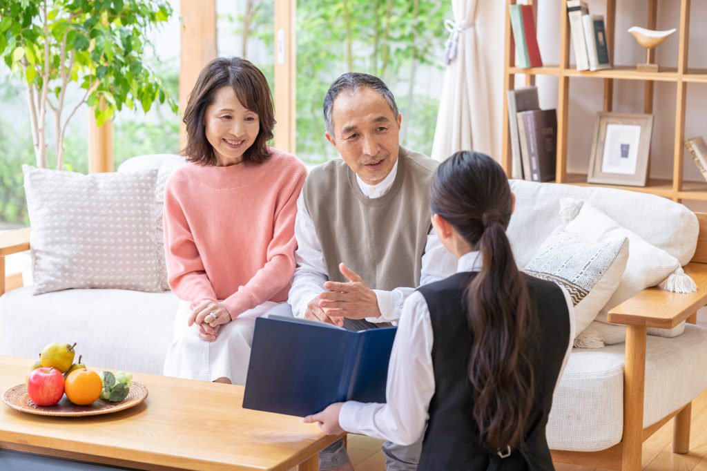 自宅で担当者から説明を受けるシニア夫婦