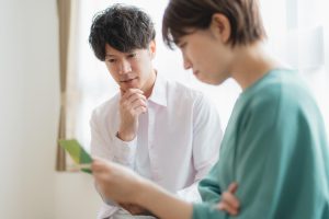 通帳を見ながら悩む夫婦