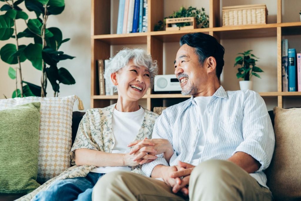 リビングのソファに座って寛ぐシニア夫婦
