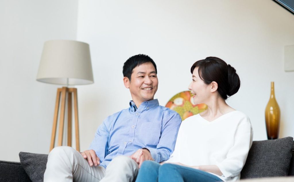 リビングで笑顔を浮かべる夫婦