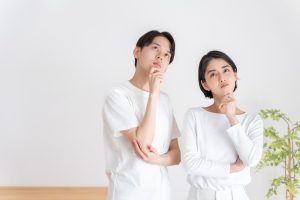 顎に手を当てて、考え事をする夫婦