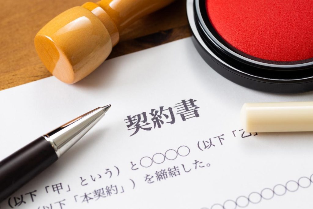 「契約書」と書かれた紙とペン、印鑑