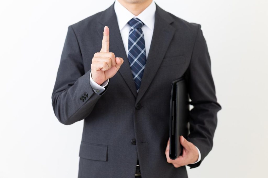 人さし指を立てるビジネスパーソン