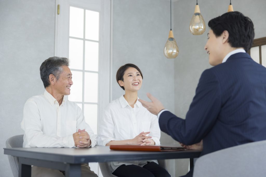 不動産会社の担当者と相談するシニアと家族