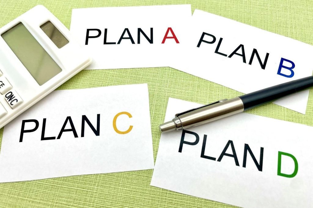 「PLAN A」「PLAN B」と順番に書かれた4枚の紙とペン、電卓