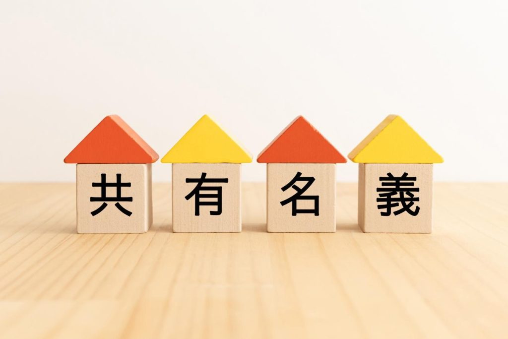 「共有名義」と書かれた屋根の付いた積み木