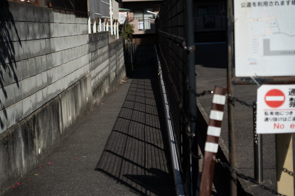標識とフェンスが設置された狭い通路