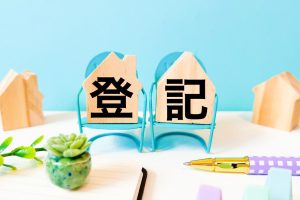 「登記」と書かれた家型の木のブロック