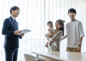 マンションの内観確認をする子連れの夫婦と営業パーソン