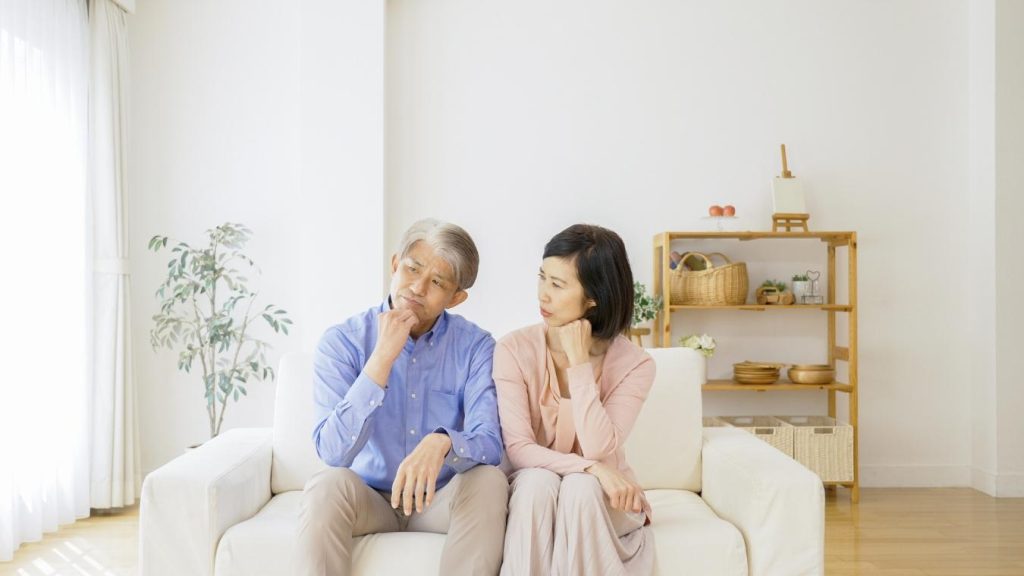 リビングで考え事をする夫婦