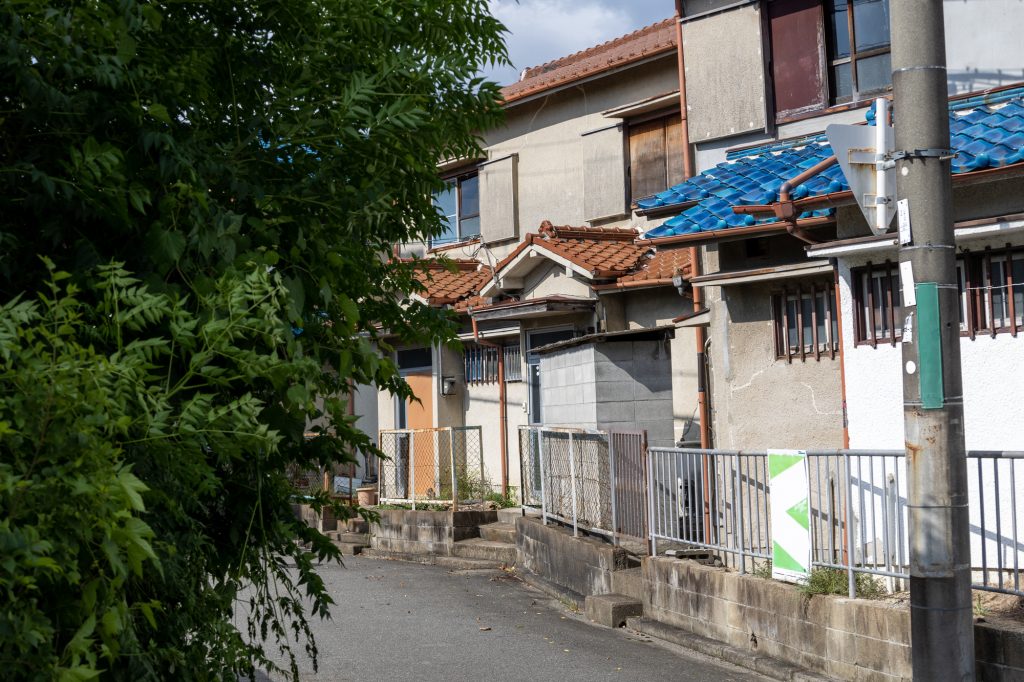 狭い道路に面して建つ古い住宅